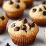 Freshly baked chocolate chip mini muffins on a wooden table