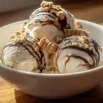 Delicious Peanut Butter Cup Ice Cream in a bowl topped with chocolate and peanuts
