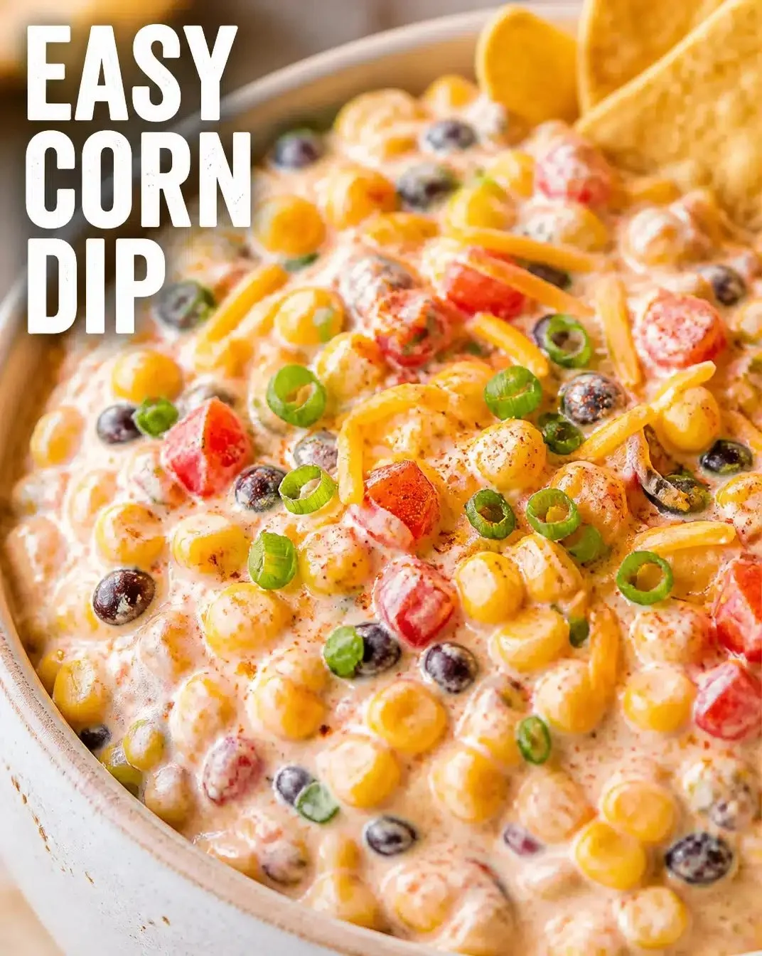 Delicious creamy corn dip served in a bowl with tortilla chips