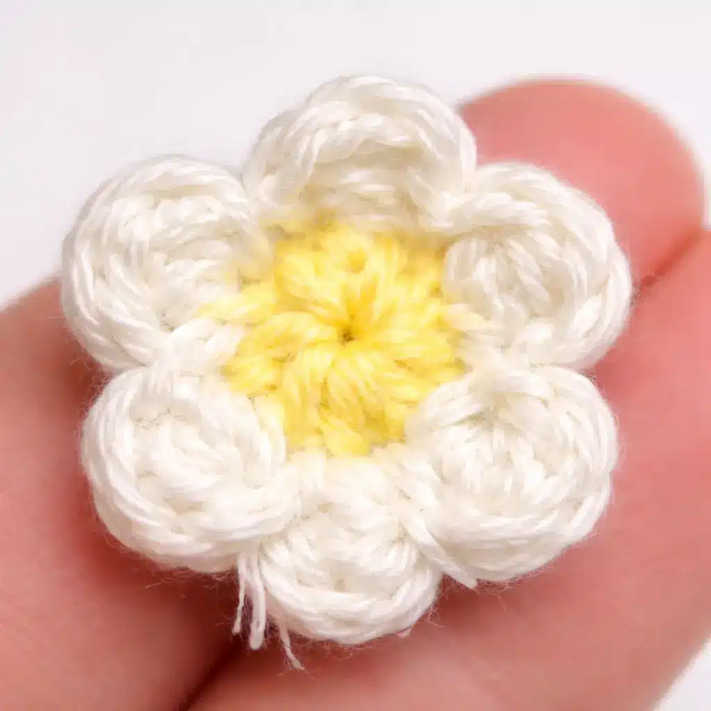 Pastel Caterpillar Crochet Pattern Free Amigurumi Tutorial 6 Flower embellishment step for pastel caterpillar crochet pattern with white petals and yellow center